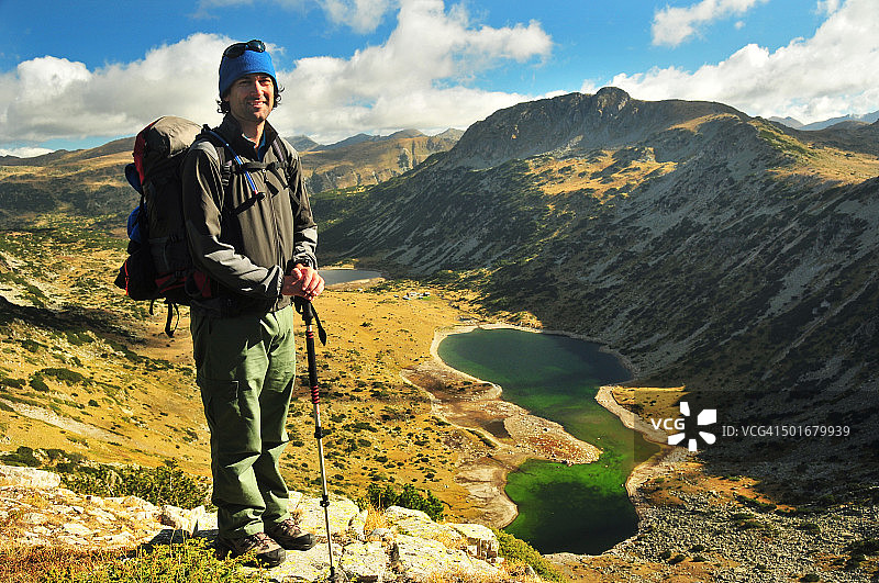 在山中携带背包和登山杖的徒步者图片素材
