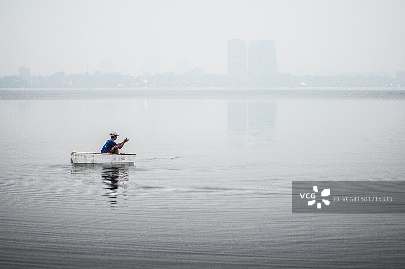 一位越南男人漂浮在西湖上图片素材
