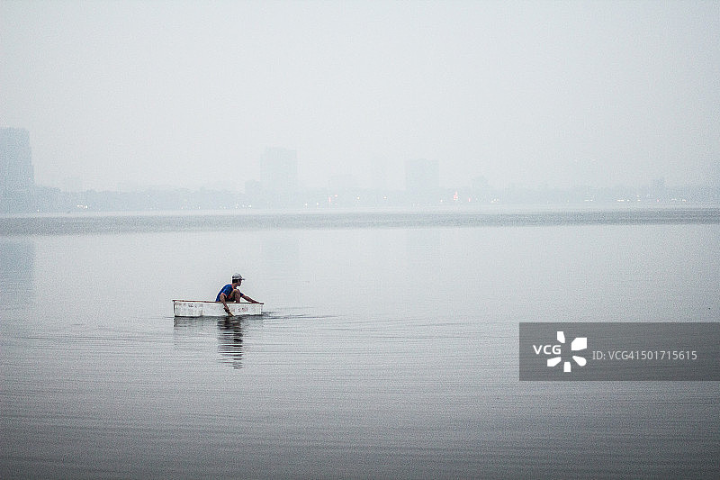 一位越南男人漂浮在西湖上图片素材