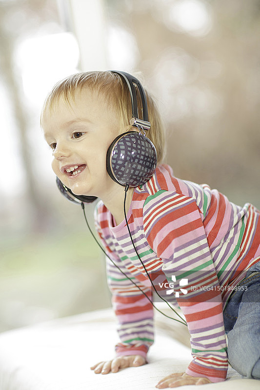 戴着耳机听音乐的幼儿男孩，克罗地亚奥西耶克，欧洲图片素材