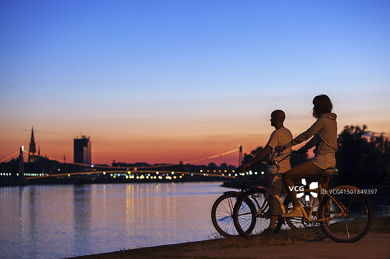 年轻情侣夜间在克罗地亚奥西耶克观赏城市夜景图片素材