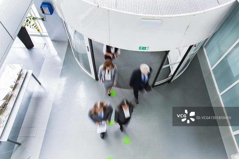一群上班族通过旋转门进入图片素材