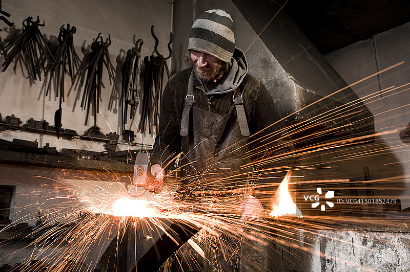 铁匠在铁砧上锤击金属，德国巴伐利亚州兰茨胡特图片素材