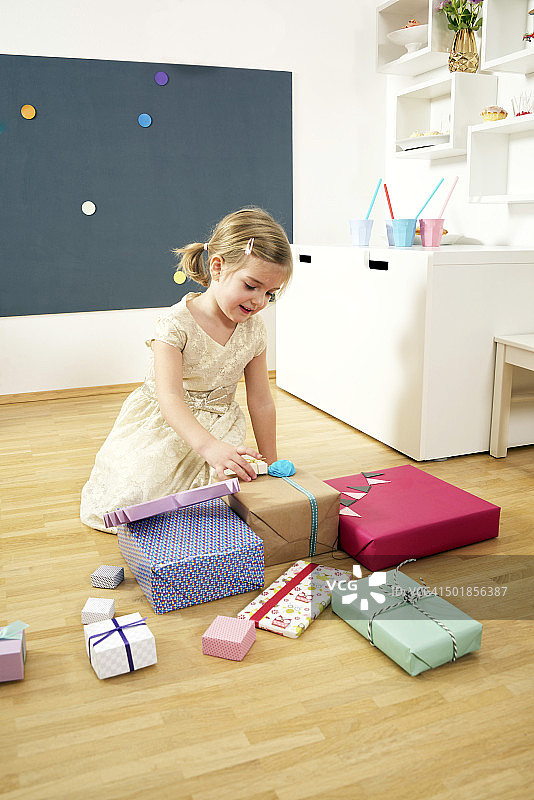 在生日聚会上拆礼盒的女孩，慕尼黑，巴伐利亚，德国图片素材