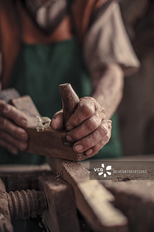 在他车间的年长木匠使用刨木机，克罗地亚巴拉尼亚卡拉纳克图片素材