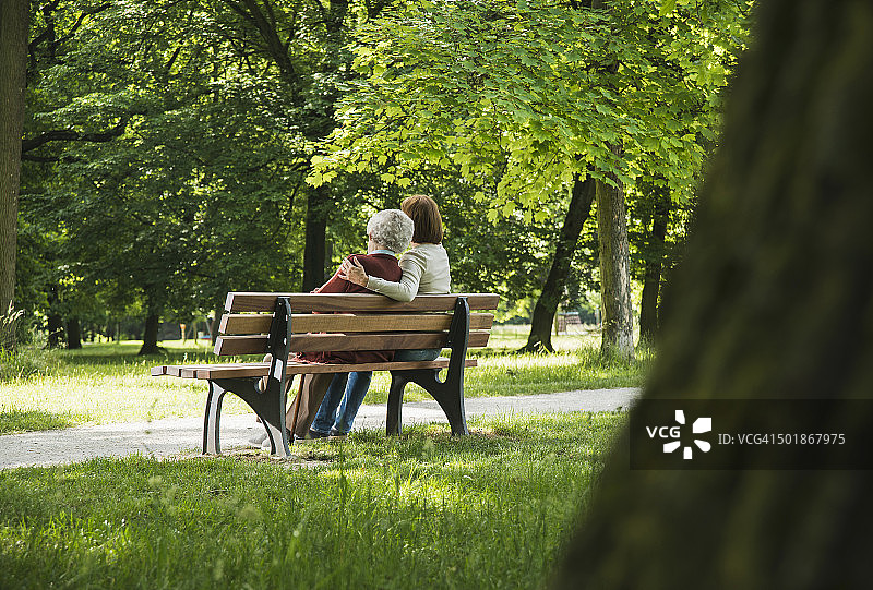 年长的女人和孙女坐在公园长椅上图片素材