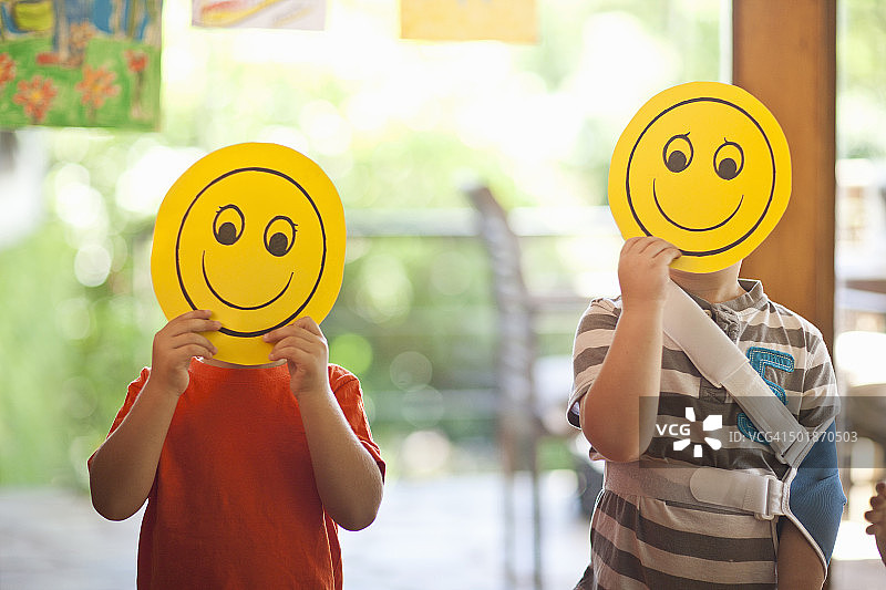 两个男孩在幼儿园拿着笑脸面具图片素材