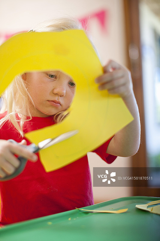 女孩在幼儿园剪纸板图片素材