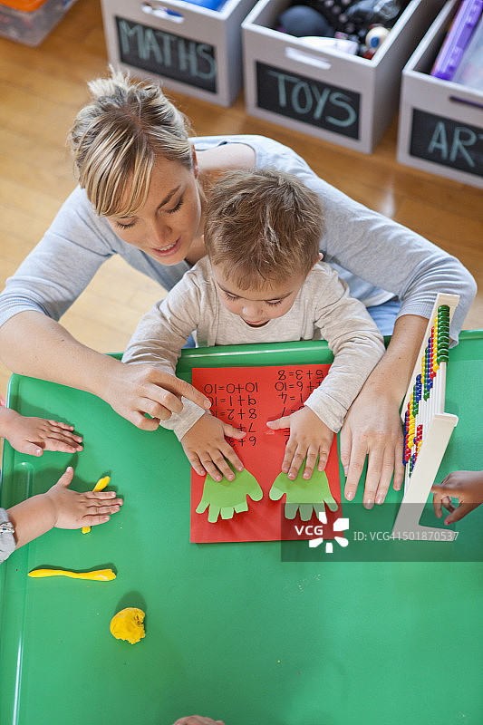 幼儿园老师和学生用手指计数俯视图图片素材