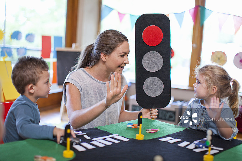 老师和小学生在幼儿园学习道路安全知识图片素材