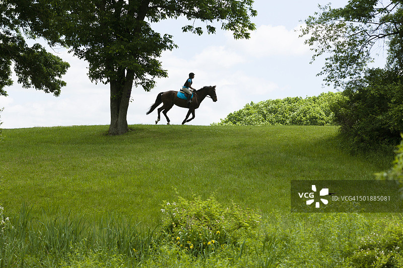 骑马者在田野风景中骑行图片素材
