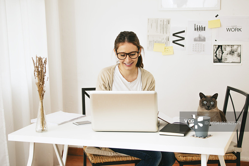 女人和她的猫坐在桌旁图片素材