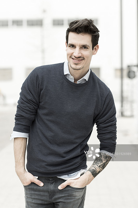 左臂有纹身的微笑男人肖像图片素材