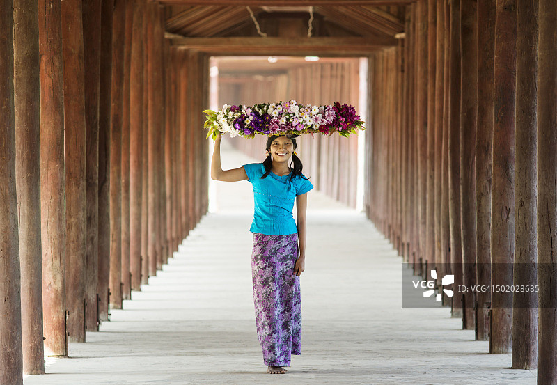 女子提着鲜花走在走廊上图片素材