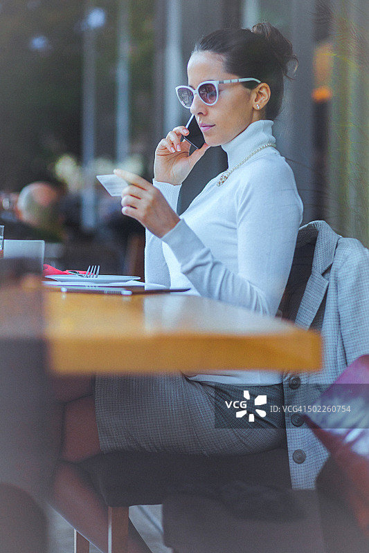 在咖啡馆使用信用卡进行在线交易的年轻女子图片素材