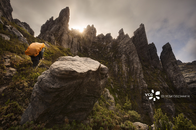在澳大利亚塔斯马尼亚西南部国家公园悬崖和尖峰中徒步的男人图片素材