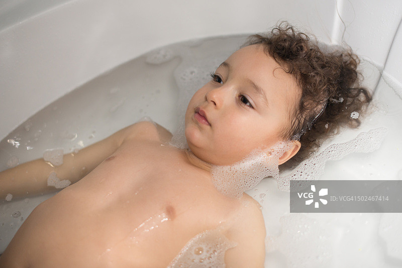 在白色浴缸里玩耍的小男孩图片素材