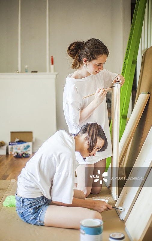 两个十几岁的女孩在粉刷家具图片素材