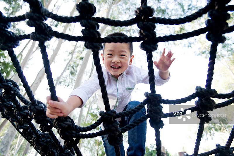 攀爬绳架的亚洲小男孩图片素材