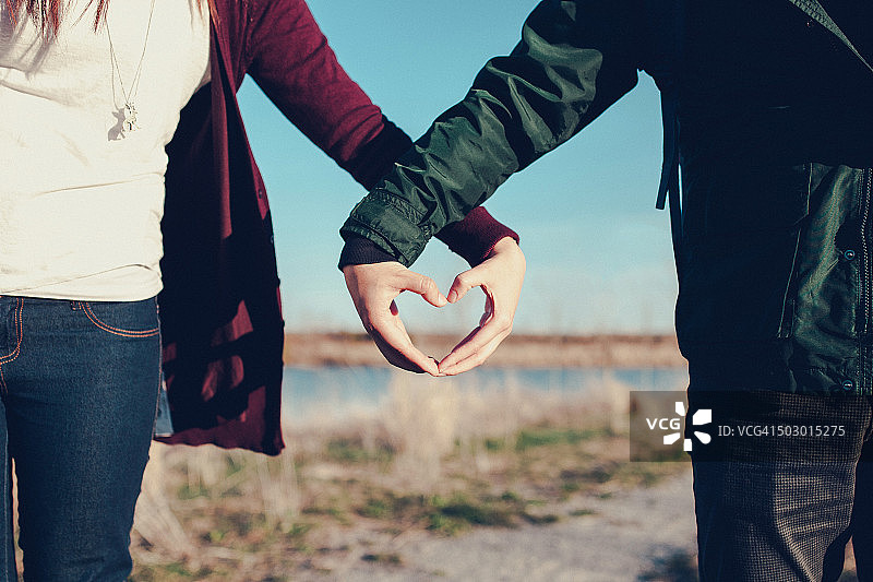 情侣在户外用手比心图片素材