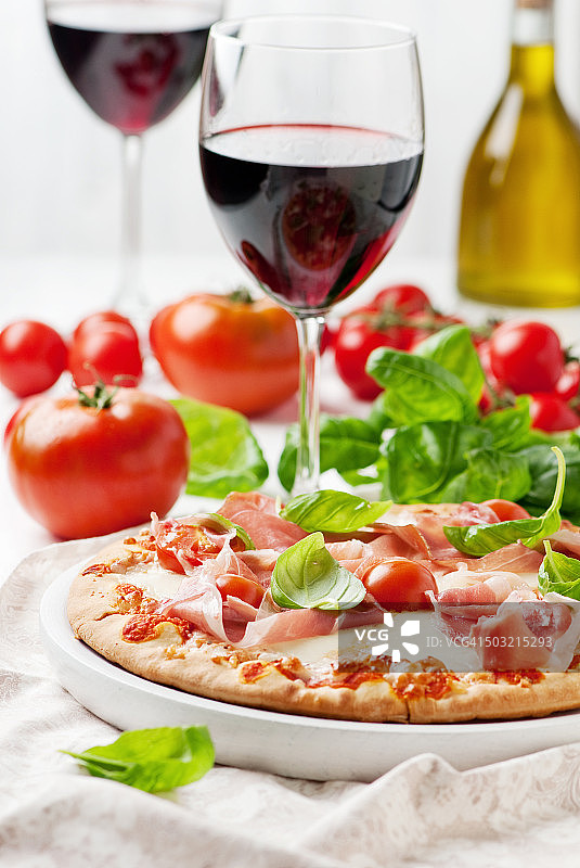 配有马苏里拉奶酪、火腿和番茄的意大利披萨图片素材