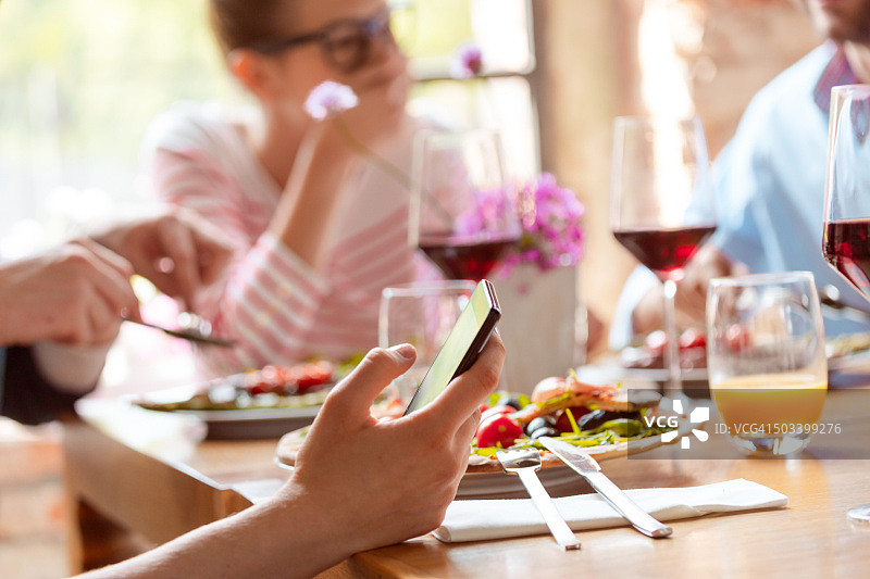 午餐时手中智能手机特写图片素材