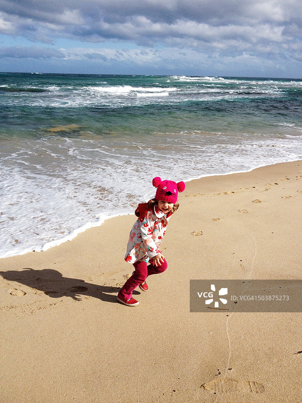 在澳大利亚维多利亚州索伦托海滩上跑步的女孩图片素材