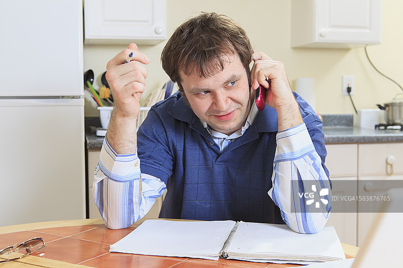 患有阿斯伯格综合症的程序员在家用电脑工作并用手机交谈图片素材