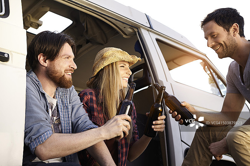 朋友们在小型货车旁庆祝图片素材