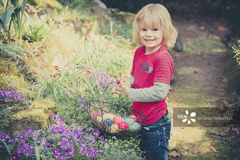 在花园里提着复活节篮子的男孩图片素材