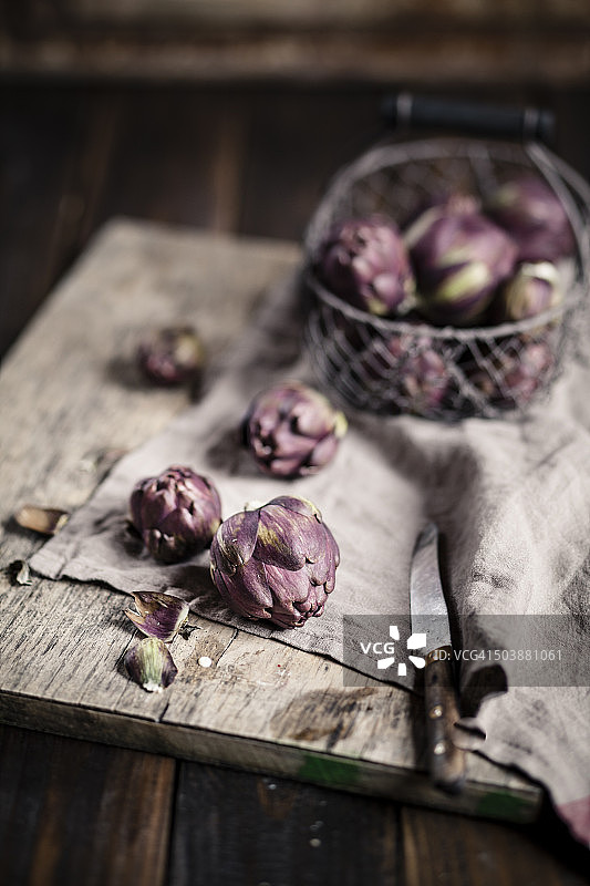 朝鲜蓟和刀在木板和桌子上图片素材