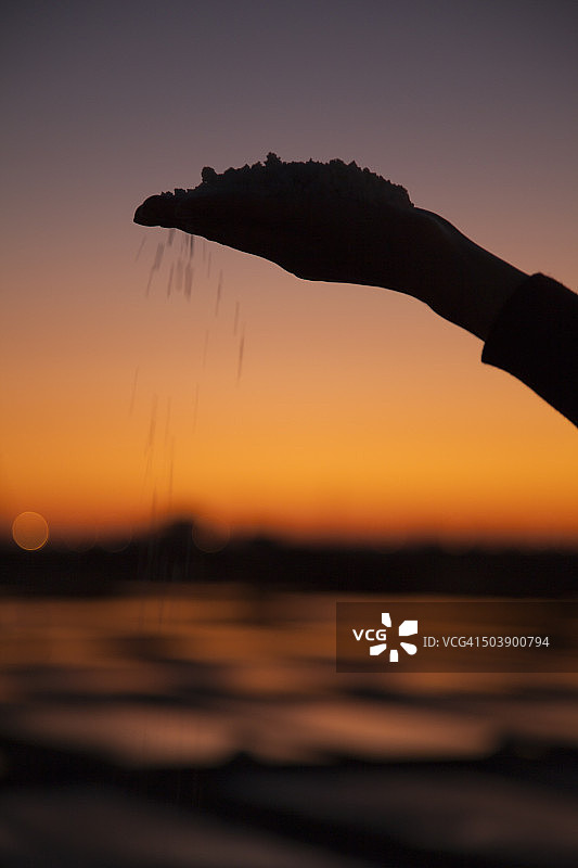 手持盐，背景是盐田图片素材