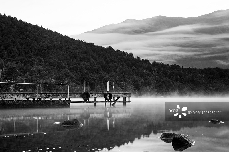 新西兰尼尔森湖国家公园罗托伊蒂湖上的黑白晨雾和倒影图片素材