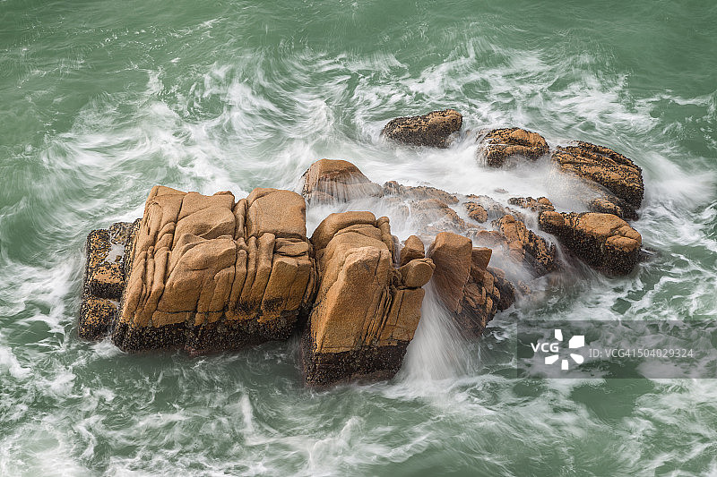 中国香港长洲岛岩石上涌动不安的海浪（俯视）图片素材