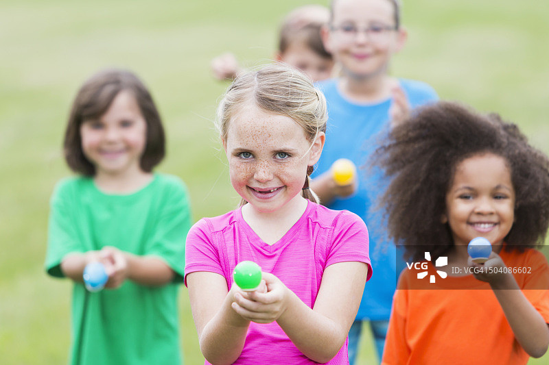 参加鸡蛋赛跑的多民族儿童群体图片素材
