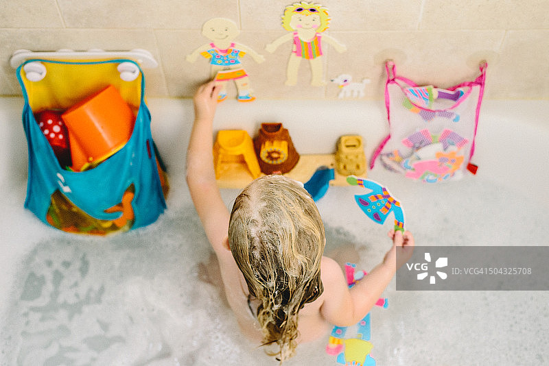 俯拍小女孩在浴缸里玩耍图片素材