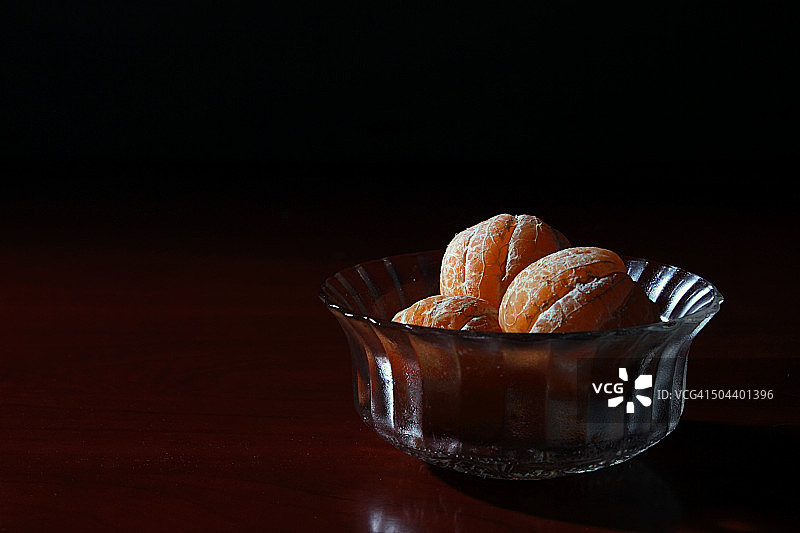 小玻璃碗上的三个去皮橘子图片素材