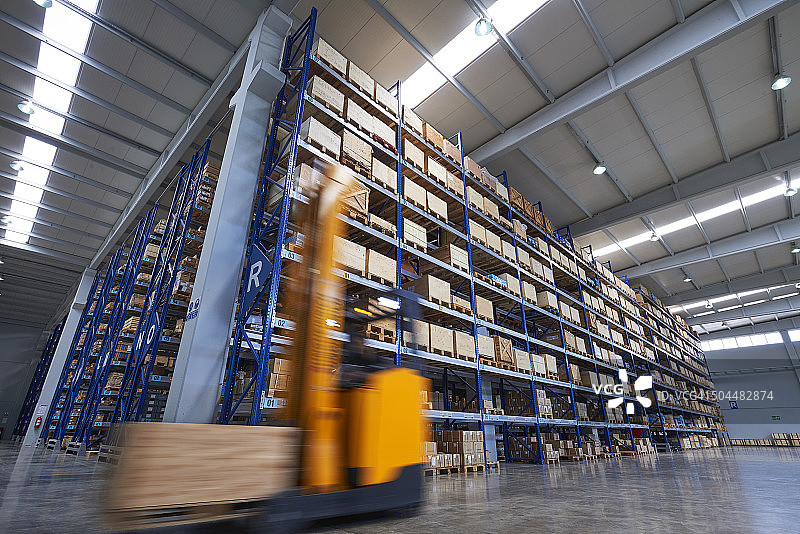 仓库中搬运纸箱的叉车图片素材