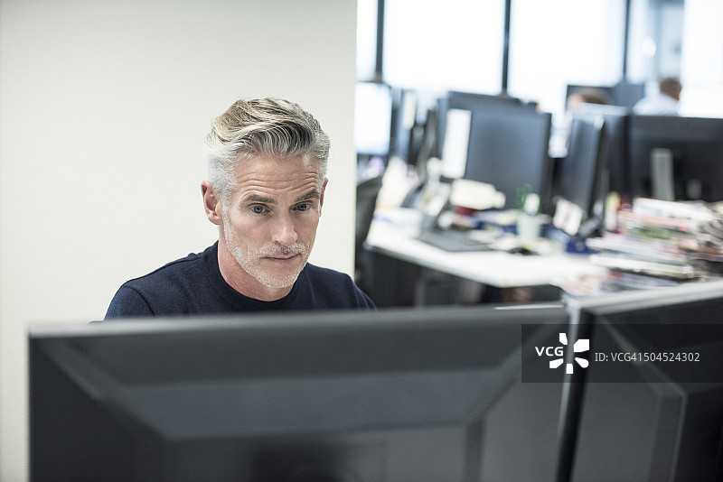 中年商人在现代办公室使用电脑图片素材