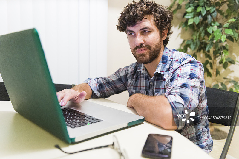 在笔记本电脑上工作的年轻美国千禧一代商人图片素材