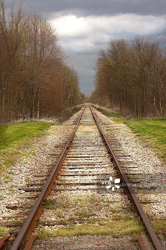 暴风雨春日天空下的火车轨道图片素材
