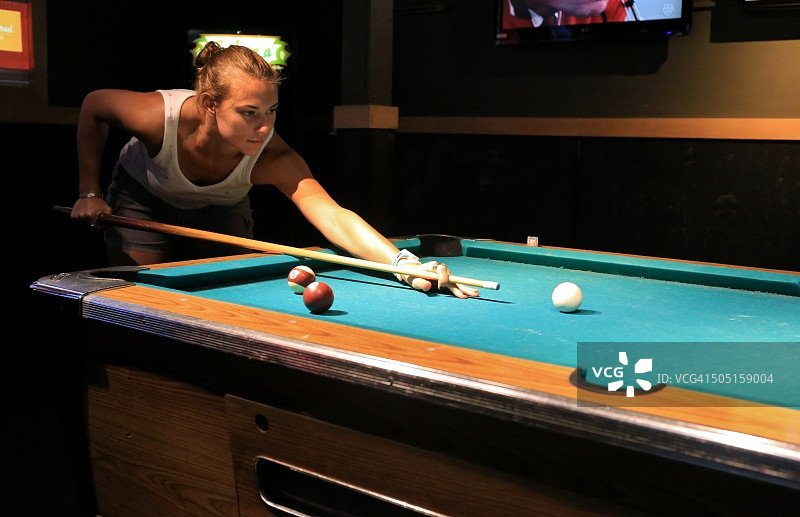 年轻女人准备击打台球图片素材