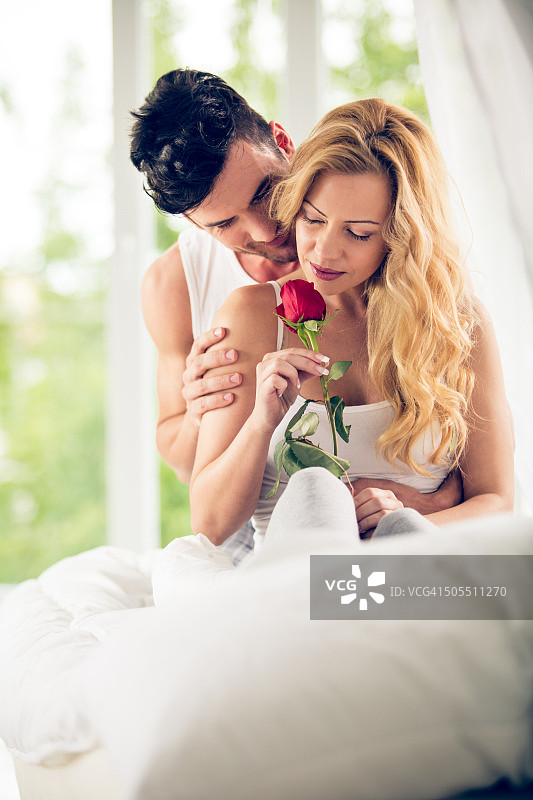 卧室里手持玫瑰的夫妇图片素材