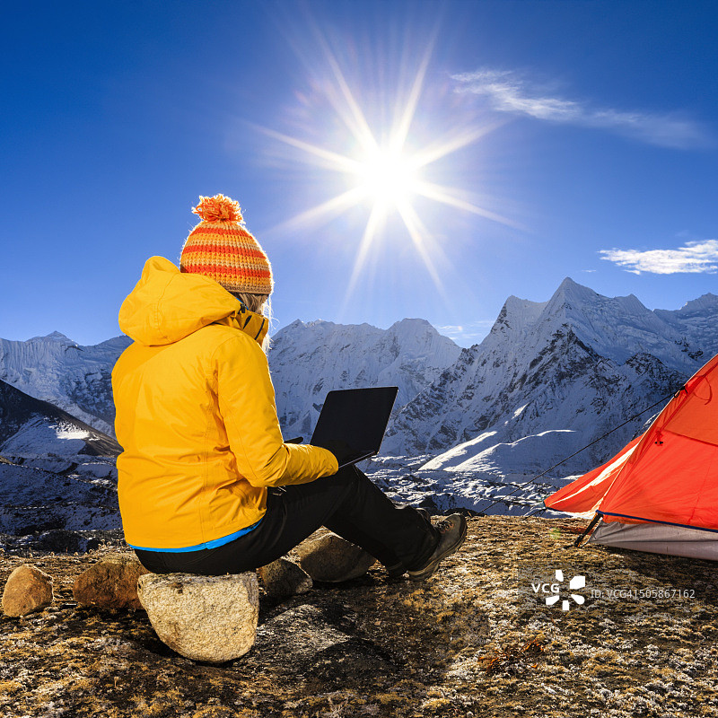 年轻女人在尼泊尔喜马拉雅山脉使用笔记本电脑图片素材