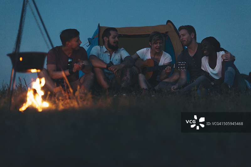 徒步旅行者在篝火旁唱歌弹吉他图片素材