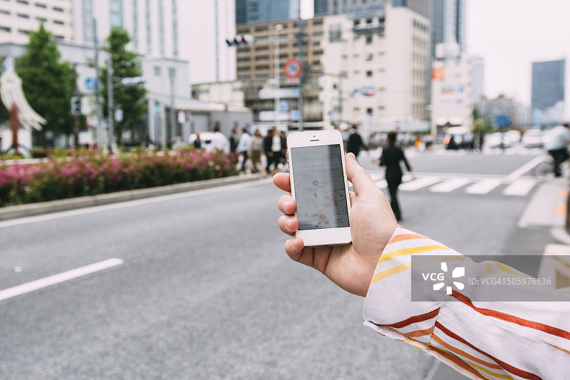 在街上手持智能手机图片素材