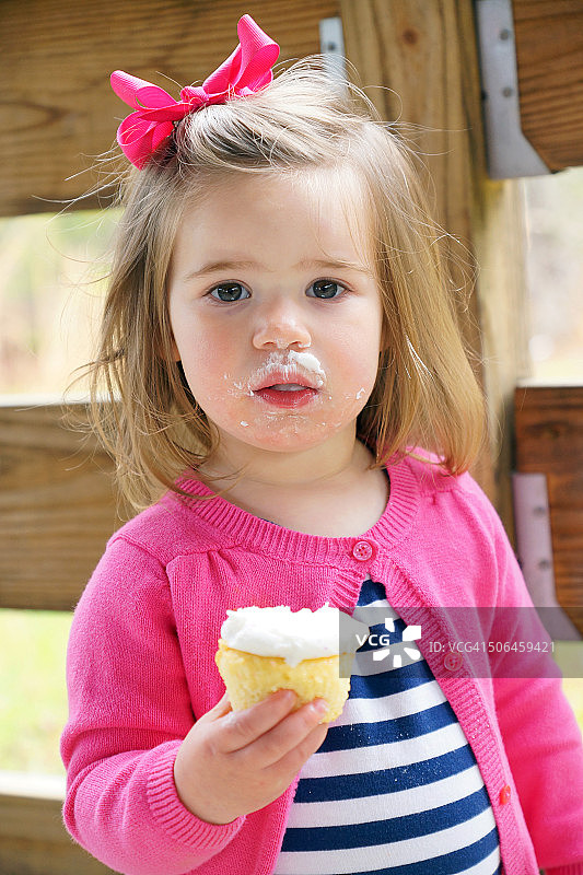 年轻女孩吃纸杯蛋糕图片素材