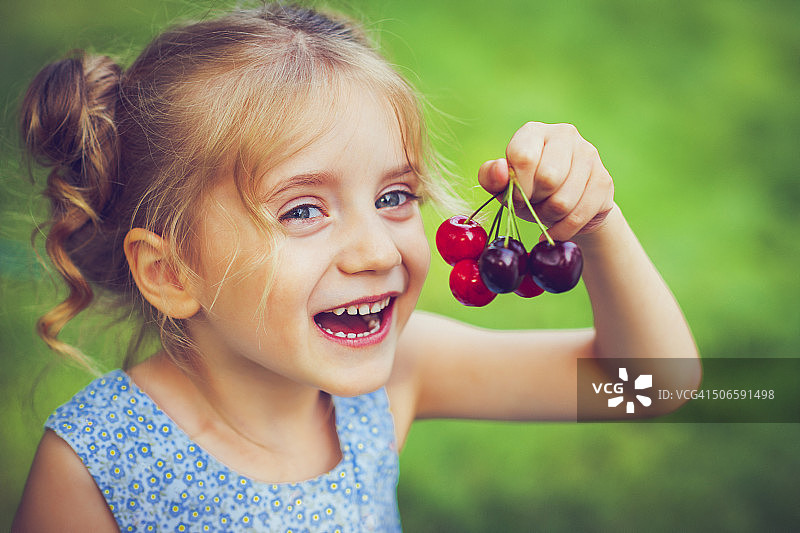 拿着樱桃的小女孩图片素材