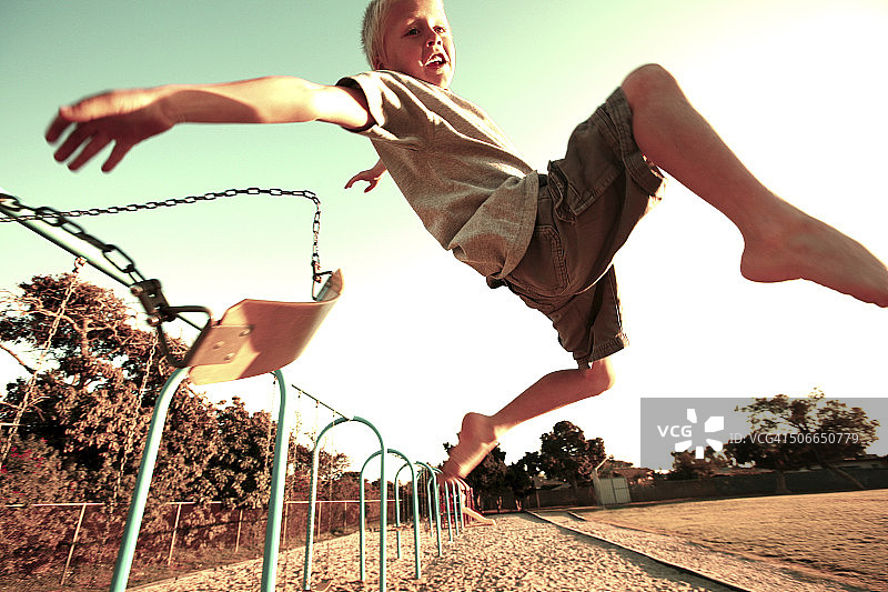 从秋千上跳下来的男孩图片素材