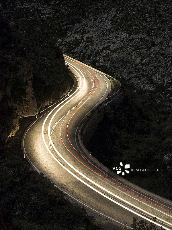 车辆移动时，灯光在夜空中划出S形曲线图片素材